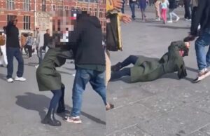 Man sleept vrouw aan haar haren over straat bij Centraal Station in Amsterdam
